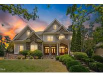 Beautiful two-story home featuring stone accents, manicured landscaping and inviting entrance at sunset at 10909 Grand Journey Ave, Raleigh, NC 27614