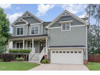Charming two-story home with a welcoming front porch, manicured lawn and attached two car garage at 1138 Bexley Hills Bnd, Apex, NC 27502
