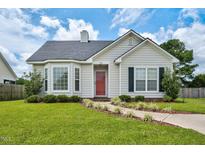Charming single-story home with a well-manicured lawn and inviting red front door at 1516 Greys Mill Rd, Rocky Mount, NC 27804