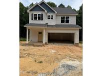 New construction home featuring light siding, a two-car garage, and a welcoming covered front porch at 161 Rollins Acres Ln, Lillington, NC 27546