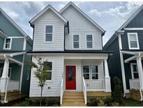 Charming two-story home featuring a bright red front door and a quaint covered porch at 1907 Plott Balsam Dr, Wendell, NC 27591