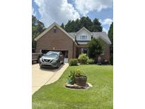 Charming brick home with well-maintained lawn, attached garage, and beautiful landscaping at 2302 Fordcrest Dr, Apex, NC 27502
