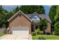 Charming brick home featuring manicured lawn, attached garage, and classic architectural details at 2302 Fordcrest Dr, Apex, NC 27502