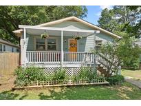 Charming home with a welcoming front porch, colorful flowers, and a bright yellow door at 2322 Stroller Ave, Durham, NC 27705