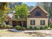 Charming two-story home with stone accents, a manicured lawn, and mature trees at 240 Oak Grove Church Rd, Youngsville, NC 27596