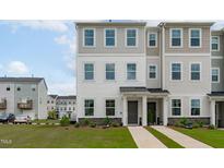 Well-maintained two-story townhouse with neutral siding, manicured landscaping, and welcoming front entries at 2539 Kasota Ln, Raleigh, NC 27610