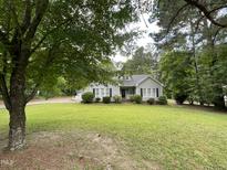 Charming one-story home with lush green lawn and mature trees offering shade and curb appeal at 313 Teresa Dr, Rolesville, NC 27571