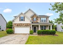 Charming two-story home featuring stone accents, a covered porch, and a well-manicured lawn at 326 Hope Valley Rd, Knightdale, NC 27545