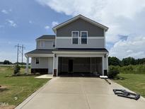 Two-story home with attached two-car garage, siding, and large concrete driveway at 37 Chloe Ct, Selma, NC 27576