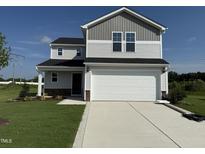Charming two-story home featuring a two-car garage, manicured lawn, and a mix of gray and white siding at 37 Chloe Ct, Selma, NC 27576