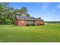 Charming single-story brick home with a well-maintained lawn and mature trees at 445 Lee County Line Rd, Broadway, NC 27505