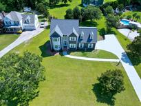 An aerial view shows a traditional-style home, lush lawn, and community pool at 5013 Wheatridge Dr, Fuquay Varina, NC 27526