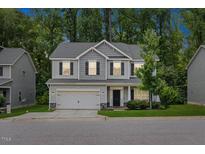 Charming two-story home with gray siding, a two-car garage and manicured landscaping at 509 Holden Forest Dr, Youngsville, NC 27596