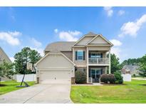 Charming two-story home with a front-facing garage, basketball hoop, and a welcoming balcony above the porch at 5637 Garnet Meadow Rd, Knightdale, NC 27545