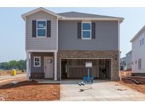 New two-story home features gray siding, brick accents, and an attached two-car garage at 648 Red River Dr, Garner, NC 27529