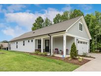Charming single-story home boasts a manicured lawn, gray siding, and a cozy front porch at 8217 White Star Dr, Fuquay Varina, NC 27526