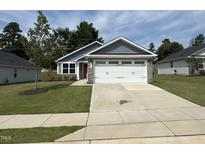 Beautiful exterior view of a single-Gathering home, showcasing a well-manicured lawn and a two-car garage at 8680 Kenridge Ln, Fuquay Varina, NC 27526