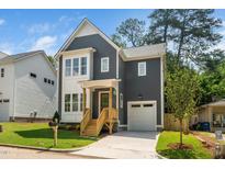 Charming two-story home with a gray exterior, white trim, covered porch, and well-manicured lawn at 905 Deboy St, Raleigh, NC 27606