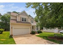 Charming two-story home with a well-maintained lawn and attached two-car garage at 9728 Batesville Dr, Raleigh, NC 27617