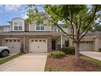 Charming townhome with a brick and siding exterior, two-car garage, and well-maintained landscaping at 1016 Kingston Grove Dr, Cary, NC 27519