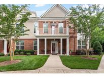 Charming brick townhome featuring a private balcony, covered entryway, and well-manicured lawn at 10310 Sablewood Dr # 115, Raleigh, NC 27617