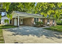Charming brick home featuring a covered carport and well-maintained front yard with mature trees at 104 S Tunstall St, Apex, NC 27502