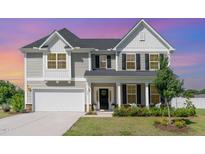 Charming two-story home featuring a welcoming front porch and manicured landscaping at 124 Airlie Place Ln, Willow Springs, NC 27592