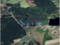 Aerial view showcasing available lots amid lush greenery and a tranquil pond setting at 12600 Old Stage Rd, Willow Springs, NC 27592