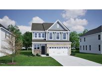 Charming two-story home showcasing stone accents and a welcoming entrance, set on a lush green lawn at 1307 Westerland Way # 16, Durham, NC 27703
