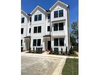 A striking modern townhouse boasts white siding, black-trimmed windows, and well-manicured landscaping at 1532 Crescent Townes Way, Raleigh, NC 27604