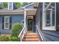 Inviting front entrance featuring a brick staircase and a dark-colored front door at 1547 Village Glenn Dr, Raleigh, NC 27612