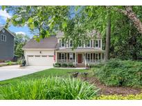 Charming two-story home featuring a welcoming front porch and well-manicured landscaping at 203 W Hill Dr, Cary, NC 27519