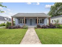 Charming blue home featuring a cozy front porch with lovely landscaping and inviting curb appeal at 208 Maywood Ave, Raleigh, NC 27603