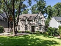 Charming home with a manicured lawn, mature trees, and a classic brick facade at 2125 Pine Dr, Raleigh, NC 27608