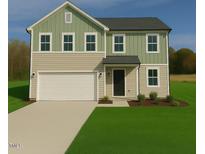 Charming two-story home featuring a two-car garage, manicured lawn, and a combination of beige and green siding at 273 Johnson Ridge Way, Four Oaks, NC 27524