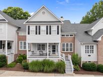 Charming two-story townhome with brick and white siding, a covered porch, and landscaped front yard at 3902 Stags Leap Cir, Raleigh, NC 27612