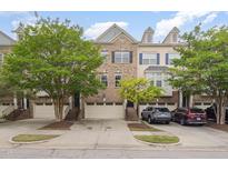 Charming townhome exterior featuring a brick facade, attached garages, and well-maintained landscaping at 404 Panorama Park Pl, Cary, NC 27519
