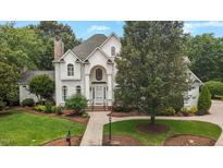 Stately white home with manicured lawn and inviting walkway leads to the front door at 4315 Sugar Pine Ln, Durham, NC 27705