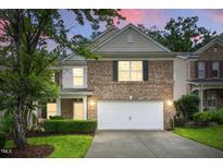 Charming brick home with a two-car garage and a well-manicured front yard at 518 Emerald Downs Rd, Cary, NC 27519