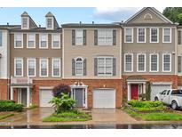 Charming townhome with brick and beige siding, complemented by a well-manicured front yard and attached garages at 5505 Heather Garden Way, Raleigh, NC 27613
