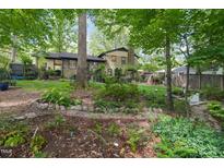 Beautiful backyard with a stone border, mature trees, and plenty of space for outdoor activities at 5523 Newberry Dr, Raleigh, NC 27609