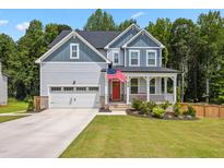 Charming two-story home with a welcoming front porch and attached two car garage at 70 Noble Heart Pl, Fuquay Varina, NC 27526
