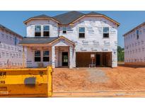 New construction home featuring a two-car garage and covered porch, with Tyvek wrap and construction materials surrounding at 756 Deschutes Dr, Garner, NC 27529