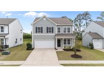 Charming two-story home with gray siding, attached garage and well-maintained lawn in a suburban neighborhood at 908 Adelphia Rd, Fuquay Varina, NC 27526