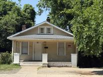 Charming, cozy single-story home with inviting porch, surrounded by mature trees at 911 Holloway St, Durham, NC 27701