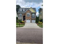 Charming two-story home featuring a stone facade, a two-car garage, and a beautifully landscaped front yard at 1016 Dotson Way, Apex, NC 27523