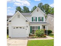 Charming two-story home with green shutters, a garage, and a well-maintained front yard at 1016 Goldmist Ln, Durham, NC 27713