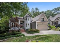 Charming home exterior featuring a two-car garage and beautiful landscaping with mature trees at 105 Gorge Ct, Cary, NC 27518