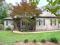 Charming home with a well-manicured lawn and a beautiful tree in the front yard at 105 Perry Ln, Zebulon, NC 27597
