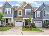 Charming townhomes featuring colorful exteriors, attached garages, and manicured lawns in a friendly community at 108 Hundred Oaks Ln, Holly Springs, NC 27540